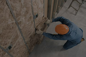 picture of a carpenter installing commercial sound and thermal insulation