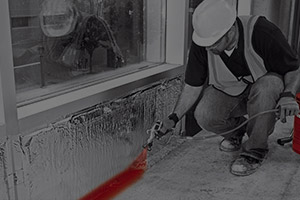 picture of a fire stopping spray being applied to a commercial building